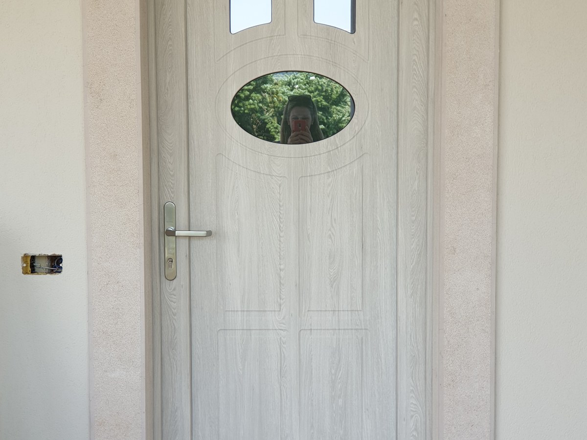 Porta d'ingresso in pvc effetto legno installata su una facciata